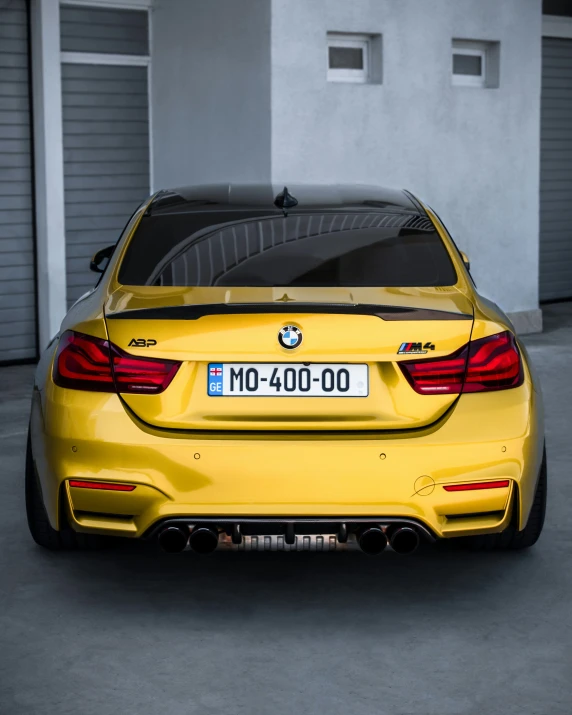 the rear end of a yellow bmw coupe