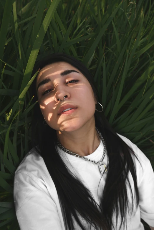 the woman has long hair and is laying in grass