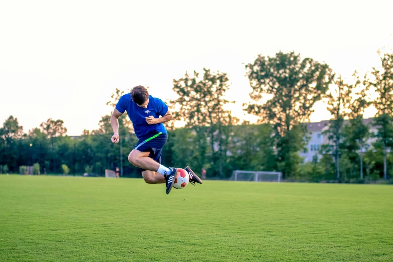 a man jumping up in the air to catch a soccer ball