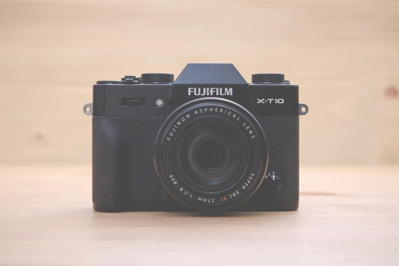 an old camera on a wooden table on display