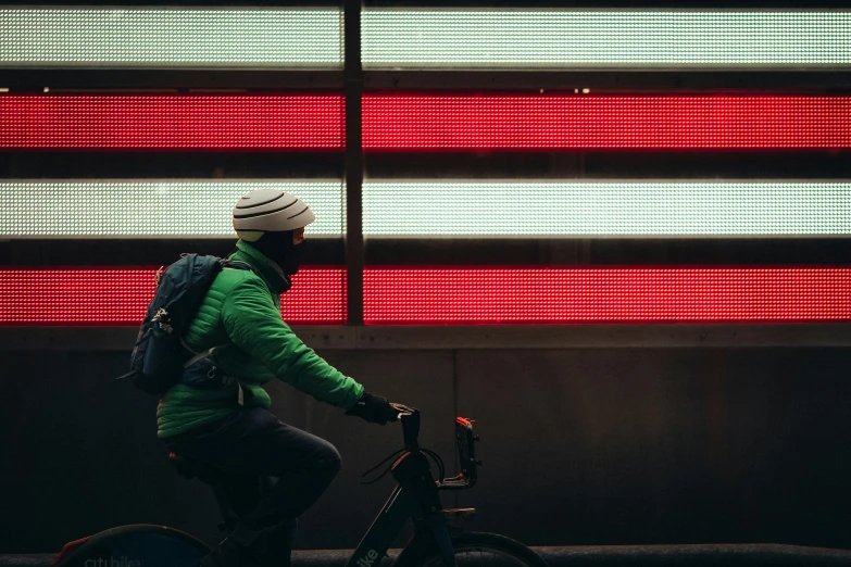 a person with backpack riding a bike by red street signs