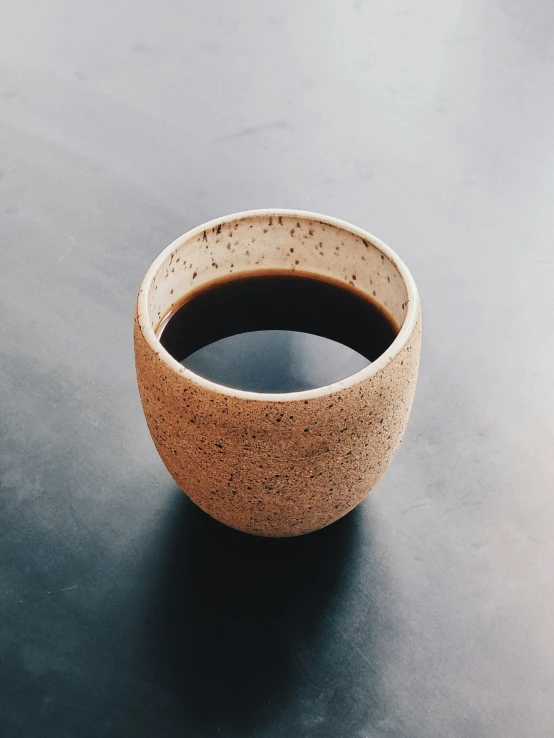 a clay bowl sits on the table with a black spot