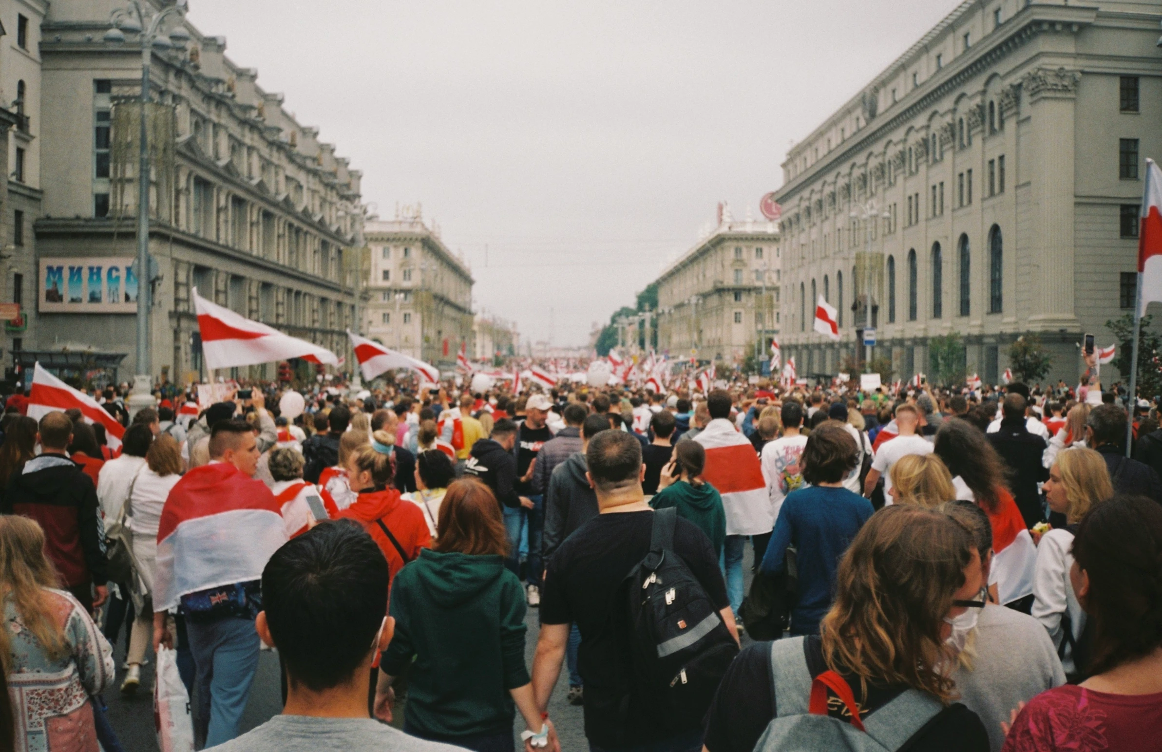 many people are walking down the street in front of some buildings