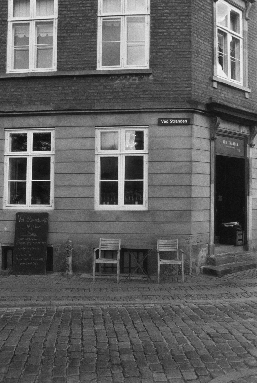 a black and white po of a house with several chairs on the front