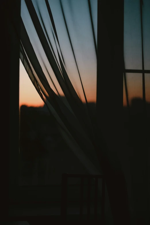 a dark window with a wooden frame at sunset