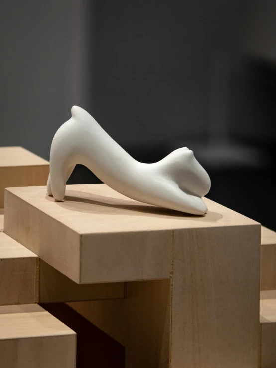 a white sculpture laying on top of two wooden blocks