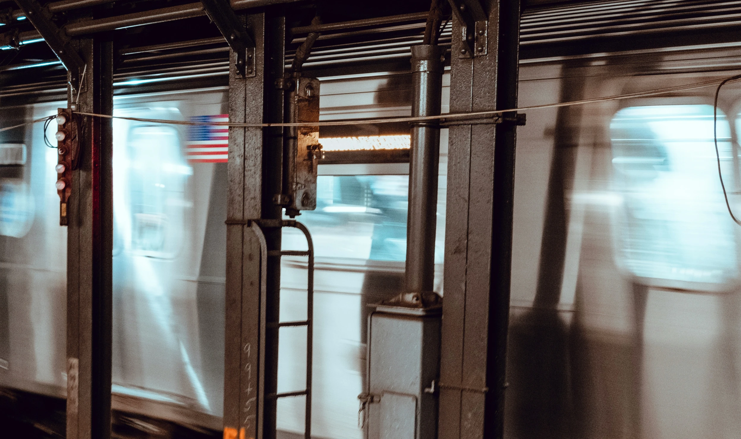 the front of a subway train at night, moving with its doors open