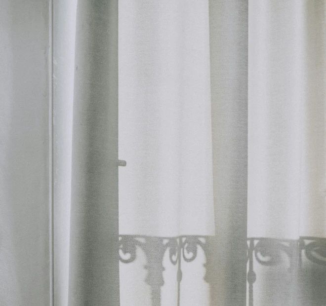 a window curtain with eye blinds with curtains and white curtains behind it