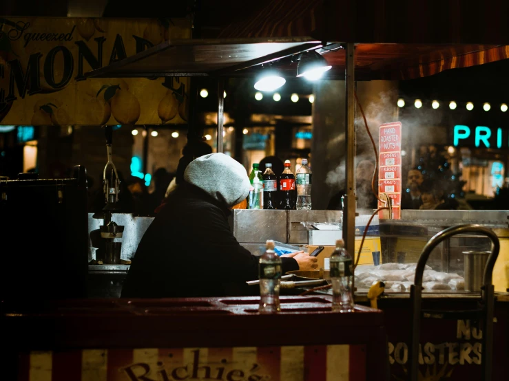 a woman sitting at a counter in front of a food court