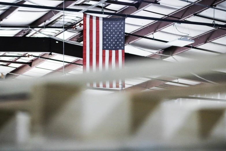 a united states flag hangs from the ceiling of a building