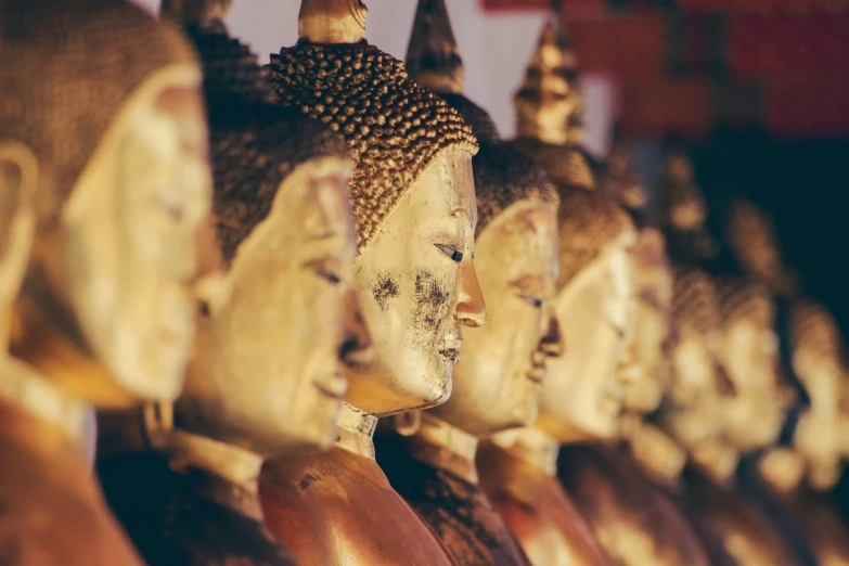 a row of buddha heads next to each other