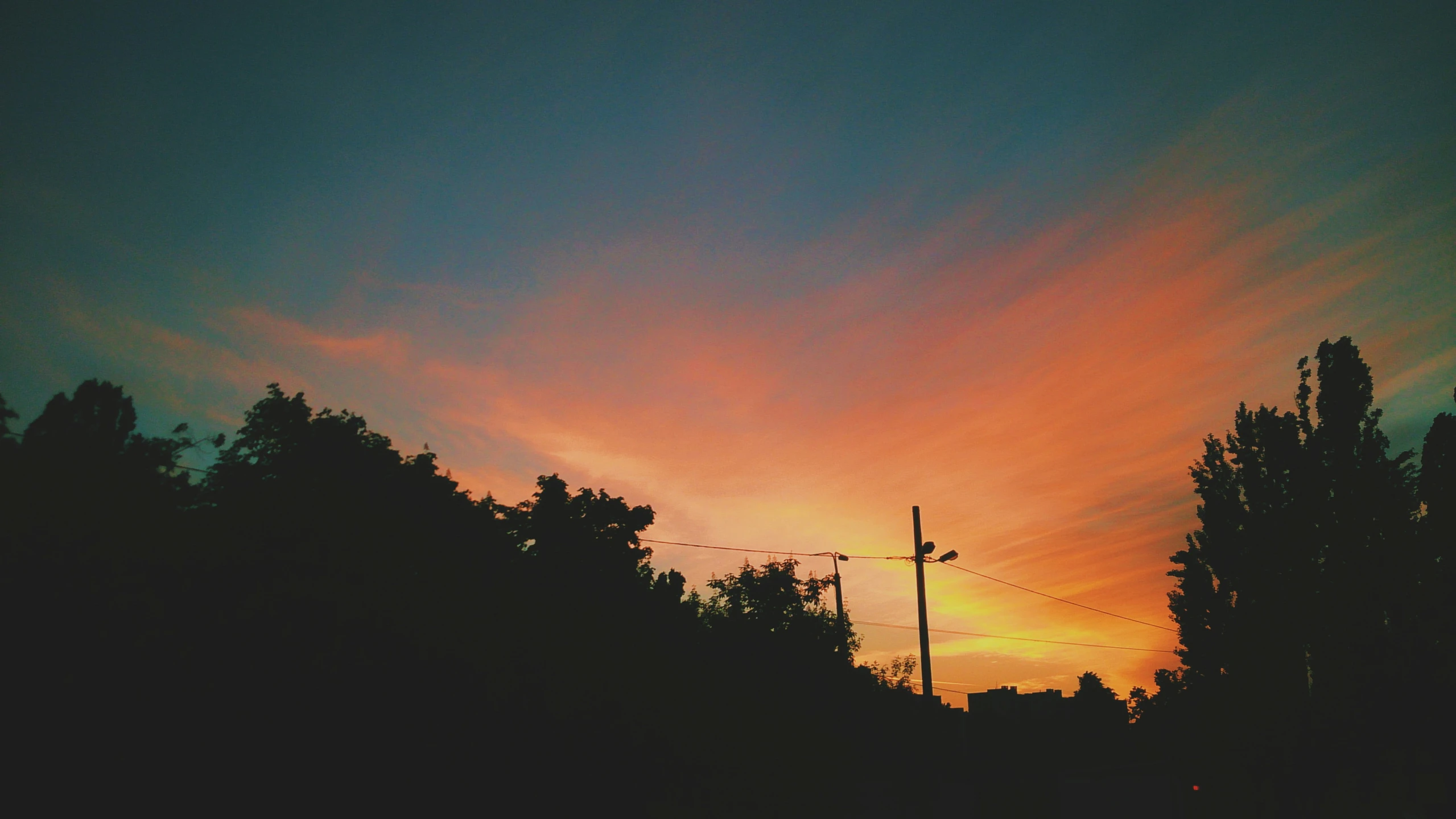 a colorful sunset and a few power lines at the top