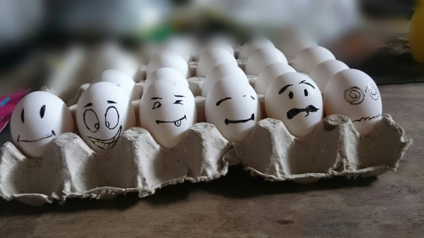 an egg carton with faces drawn on them