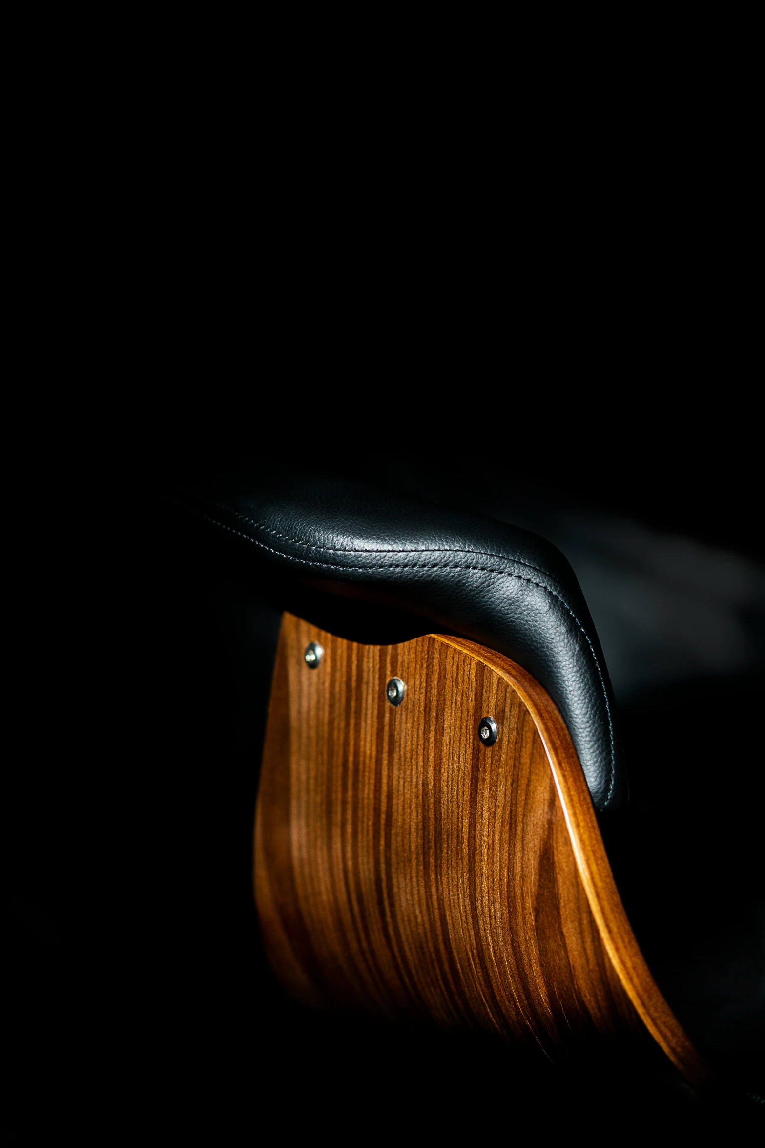 the black and wood bench is shown against a dark background