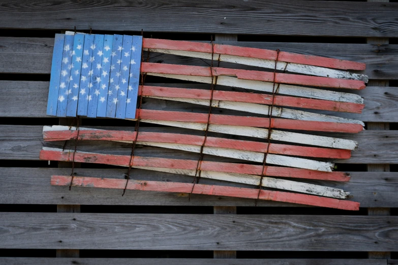 a piece of weathered wood with an american flag on it