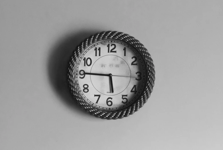 a clock is displayed against a gray wall