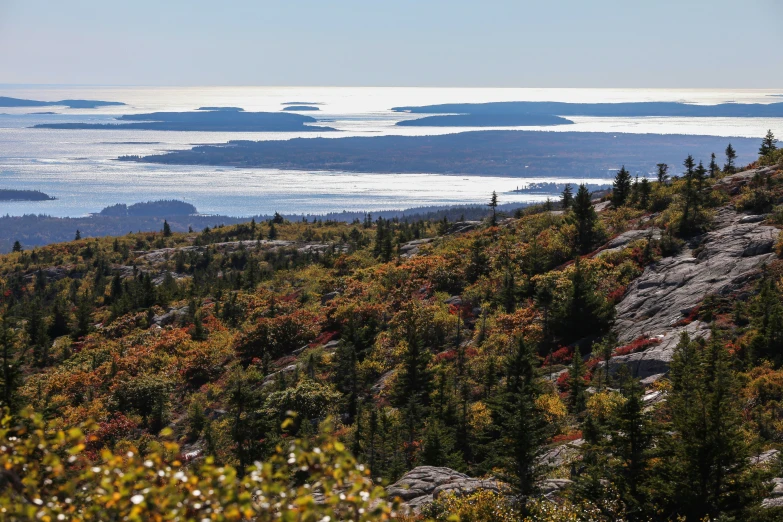 an open mountain side with a small body of water in the distance