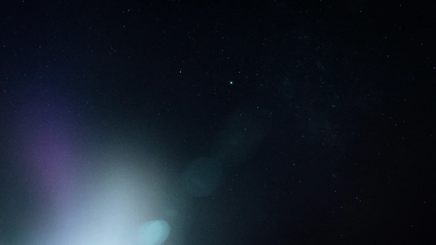 a snowy field with a white frisbee and the night sky in the background