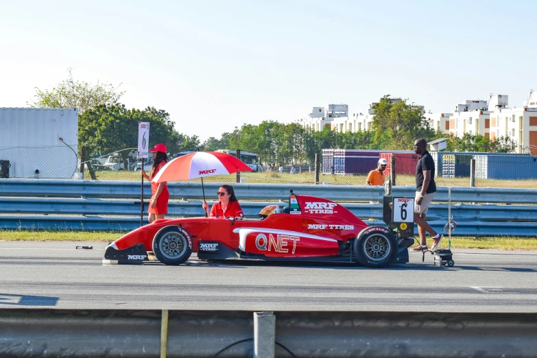 a person sits in a small racing car on the track