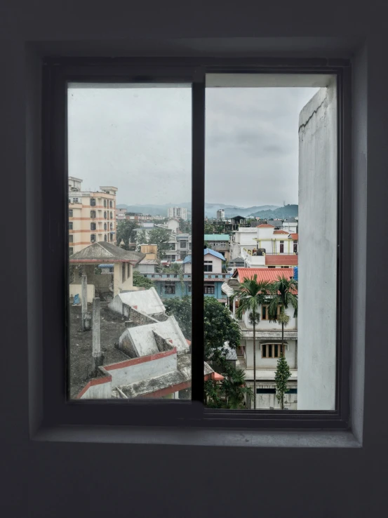 a window view outside the bathroom shows a city
