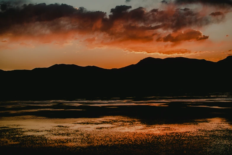 dark and colorful sunset with large mountain behind it