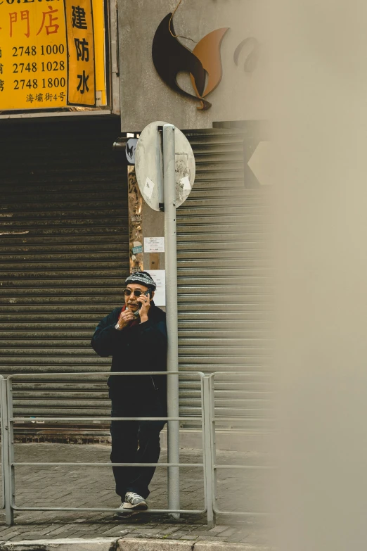 a man on his cellphone while standing in front of a building