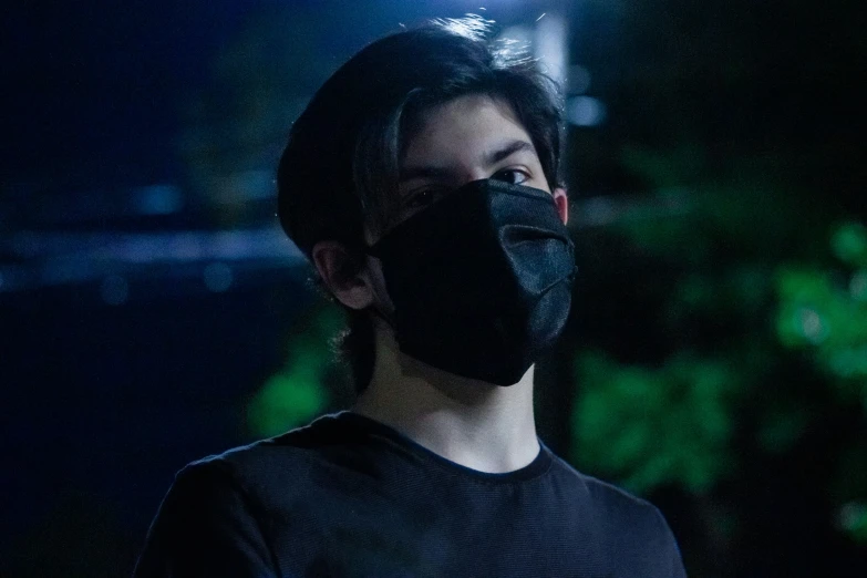 a man wearing a dark face mask with bright lights behind him