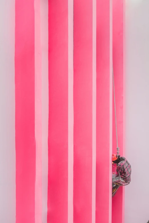 a man on a snowboard on top of pink striped walls