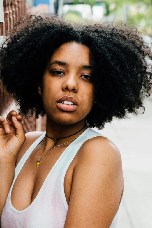 a woman with large afros on her face posing for a po