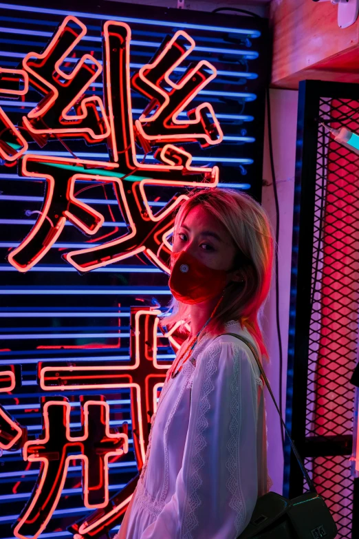 a woman in white wearing headphones next to neon sign