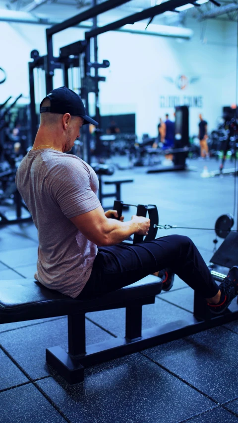 a man sits on a bench in a gym