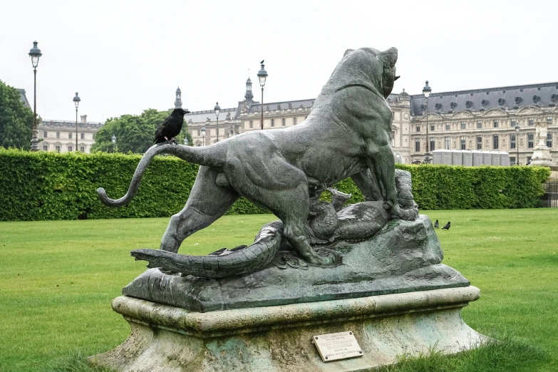 a statue of a lion and a cat on the grass