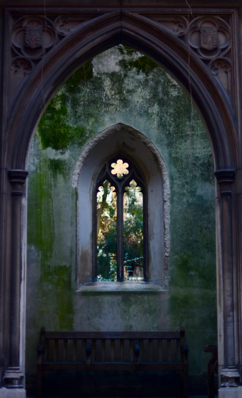 a window in an ancient building, with a bench