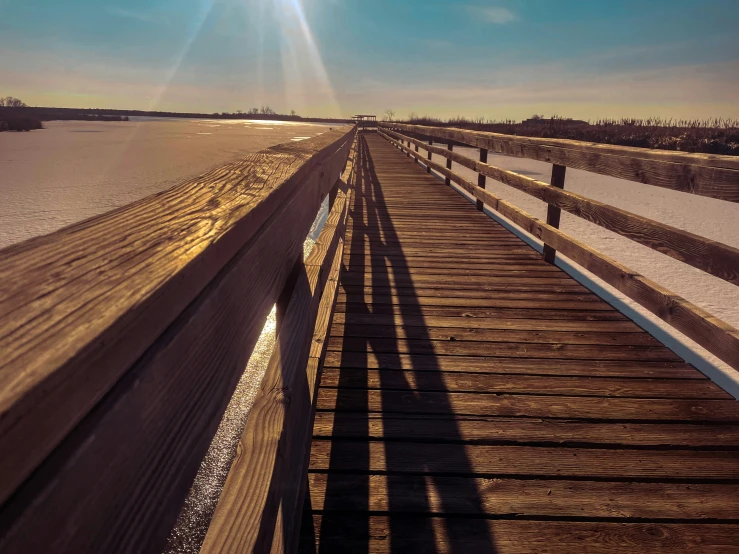 a pier next to the beach with a large body of water near it