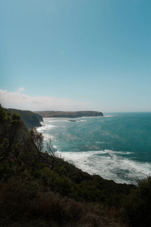 the ocean near a cliff in the distance