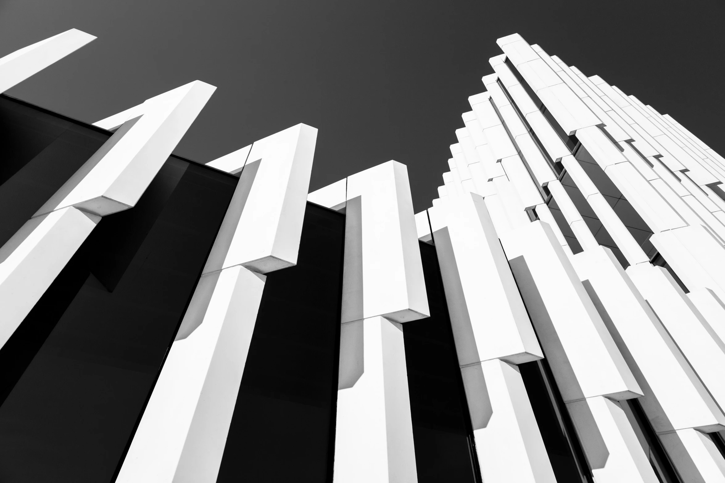 black and white pograph of abstract architecture against blue sky