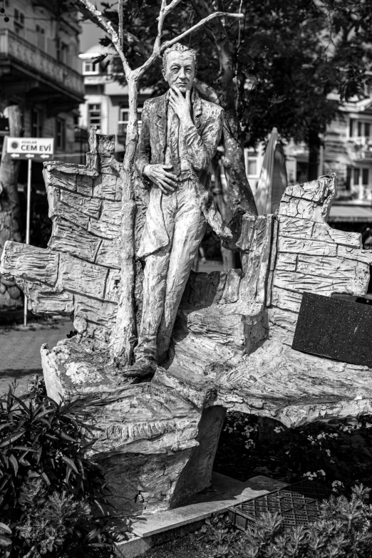 the statue of a man sitting on top of a log