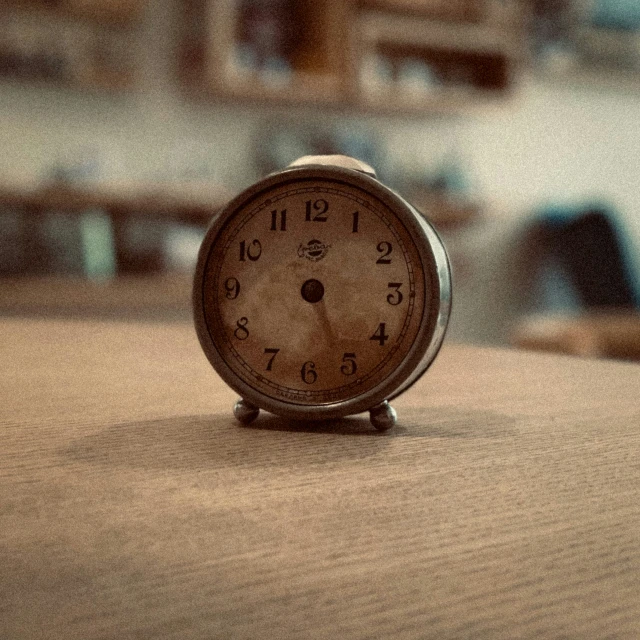 an alarm clock on the table with other items in the background