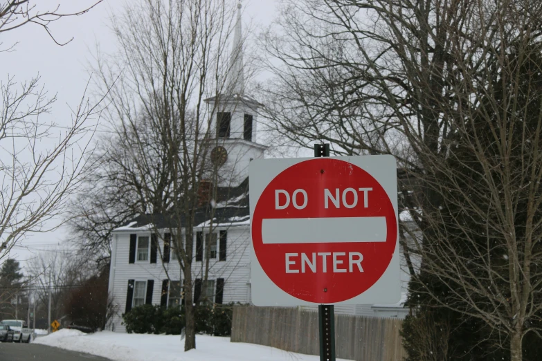 a do not enter sign stands in front of a white and black building
