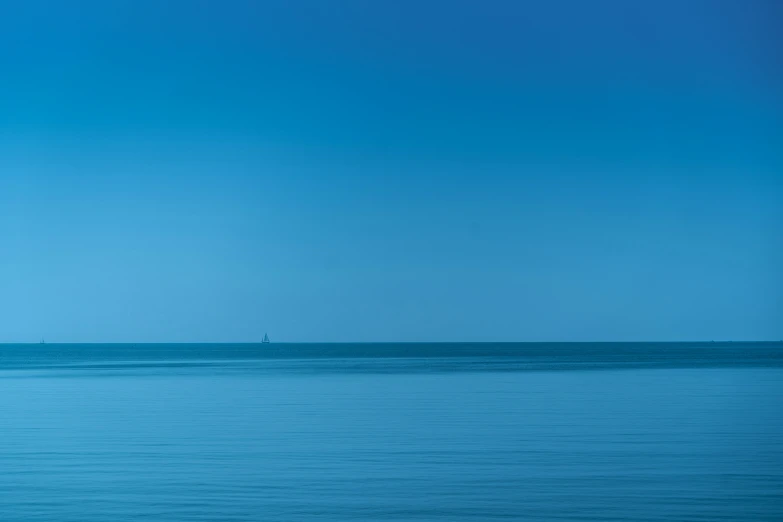 a blue ocean with a couple people on a white boat