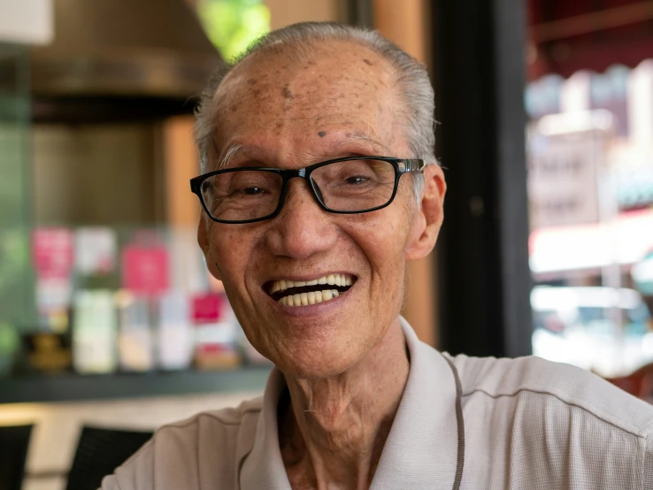 an old man is smiling while sitting down