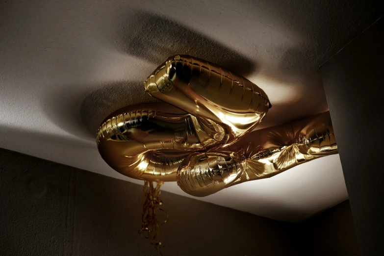 gold balloons hanging from a ceiling in the dark