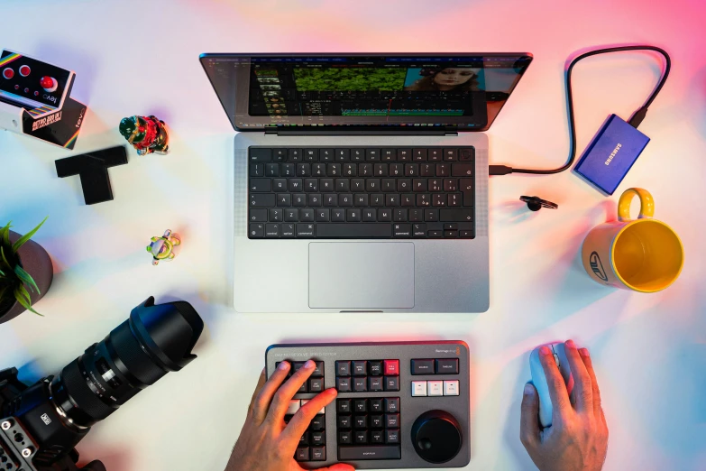 someone holding an camera and working on a laptop computer