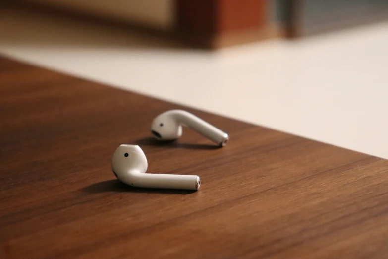 two ear buds with a white plastic cord