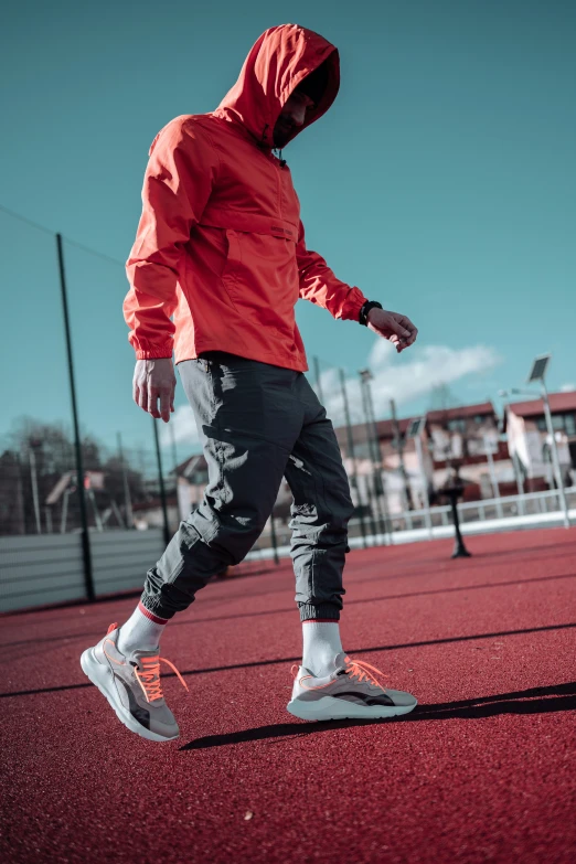 a person wearing red shoes with a red sweatshirt and black pants