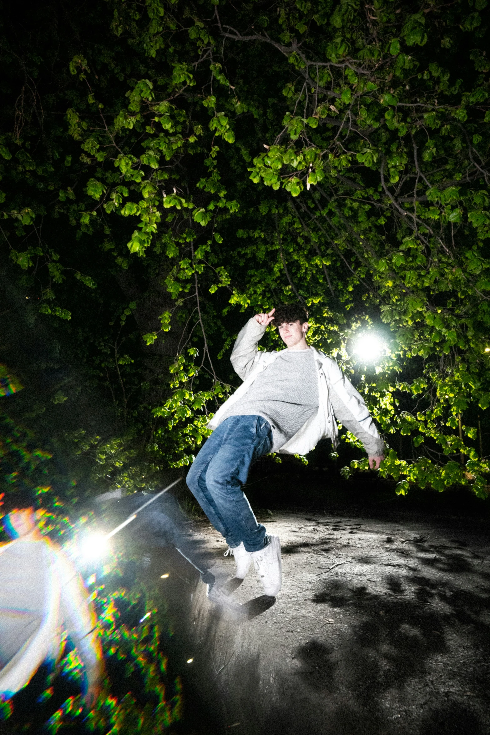 a man with white jacket and jeans in the street