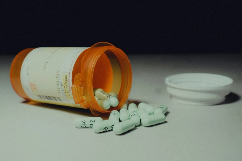 pills spilled on a table next to a pill bottle