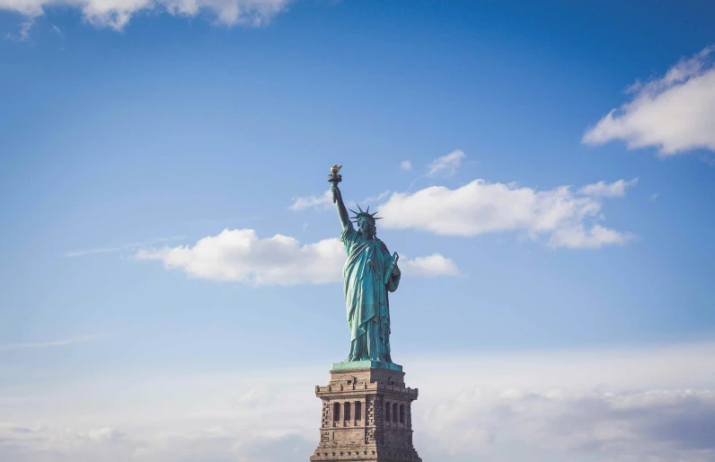 a large statue with its arms spread in front of the city