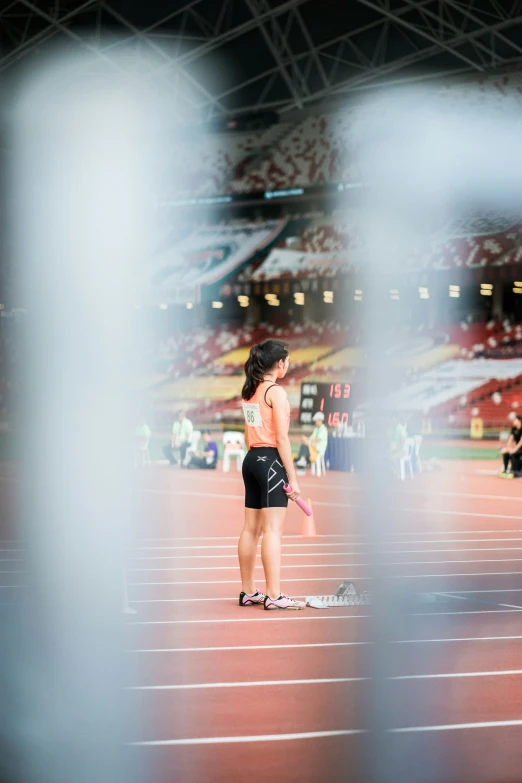 a woman in shorts holds a racket on a race track