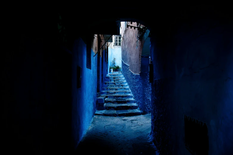 a night view looking down an alley way with steps up into it